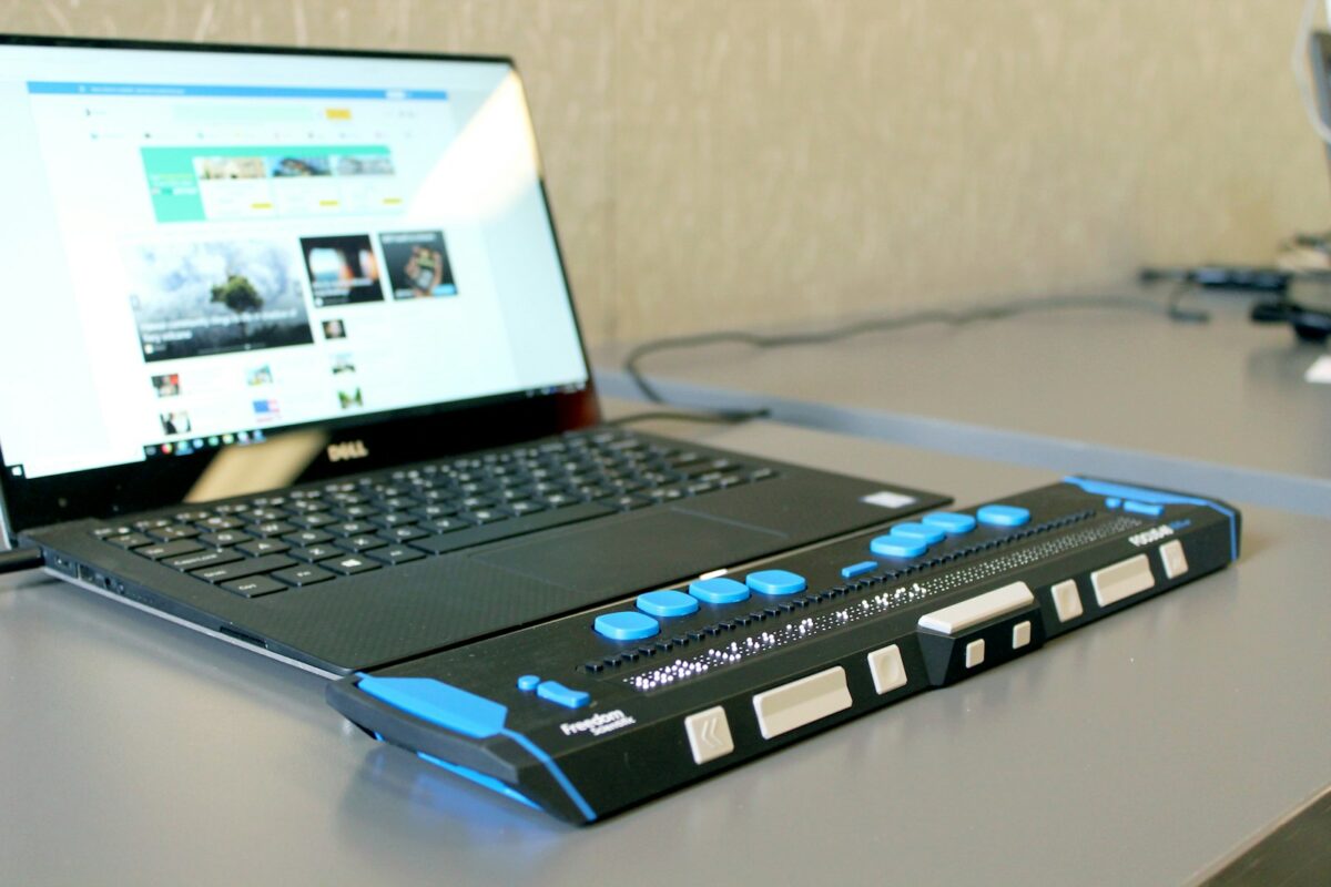 Braillezeile neben einem Laptop, auf dem eine Website geöffnet ist